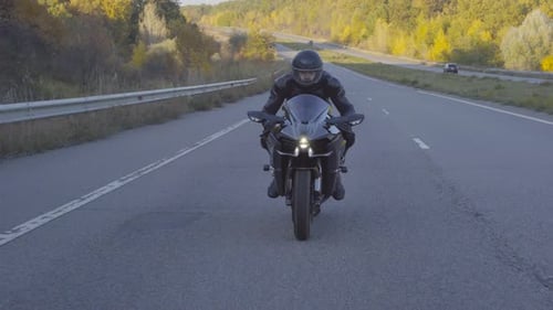 Front View of Male Biker in Protective Helmet Riding Fast on Sport Motorbike at Highway