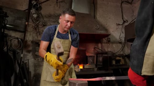 Blacksmith Forging Red-Hot Metal in Dimly Lit Workshop