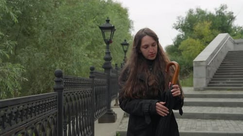 Female on Steps Solitary Woman in Black Coat Enjoying Peaceful Park Walk Enigmatic Woman in Brown