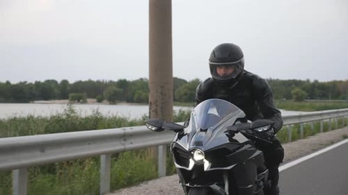Man Riding on Modern Sport Motorbike at Countryside Road Near River or Lake Motorcyclist Racing His