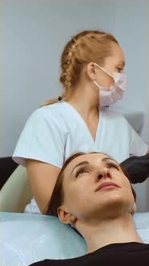 Cosmetologist Preparing Syringe for Aesthetic Injection Near Patient Face Vertical Orientation