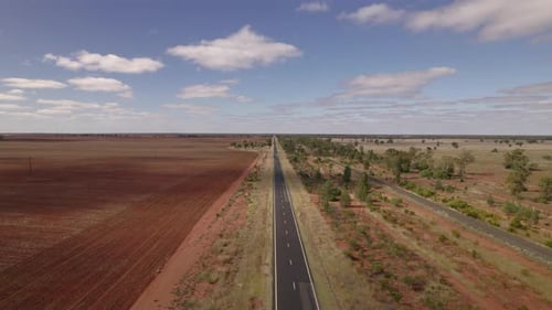 Un véhicule solitaire emprunte une autoroute dans l'outback australien depuis un horizon infini