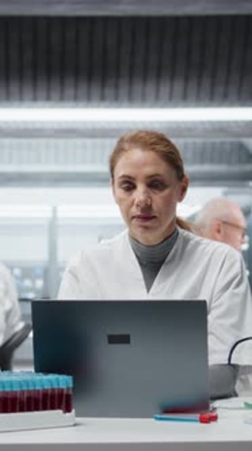 Focused Woman Using Laptop in Laboratory Setting