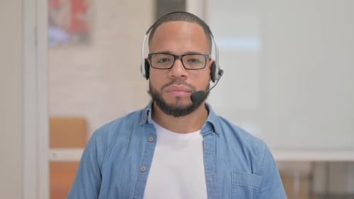 African Man with Headset Looking at Camera in Call Center