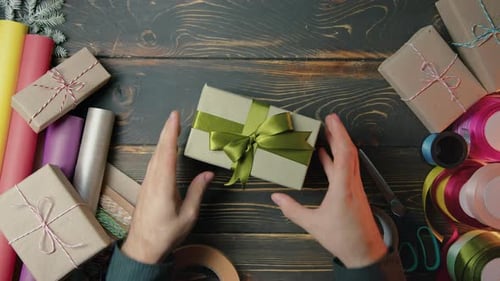 Gift Wrapper Man Hands Beautifully Gives It to Woman Top View Receiving Green Presents