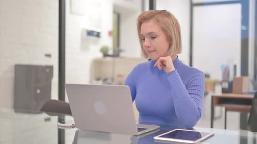 Pensive Young Woman Sitting in Office