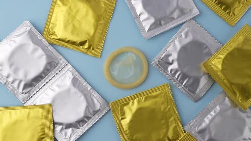 Showing packets of condoms on a blue background.