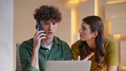 Worried Coworkers Talking Smartphone Collaborating at Office with Laptop Closeup