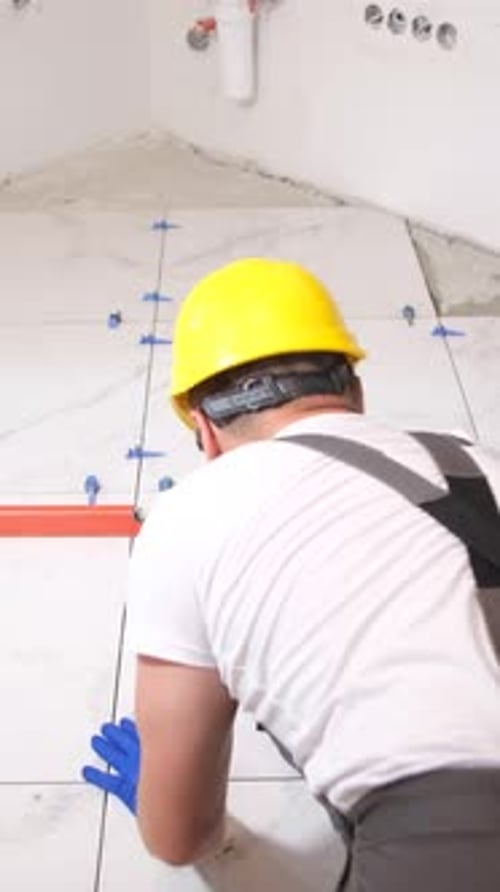Man Installing Large Format Marble-look White Tiles