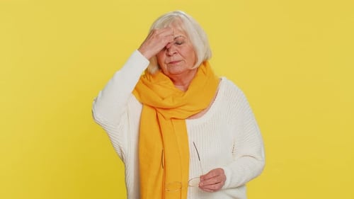 Senior Woman Massaging Nose, Cleaning Glasses, Pointing