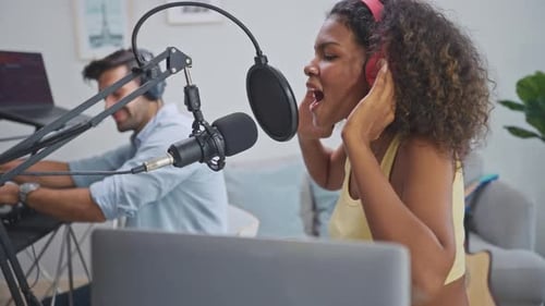 Diverse young stylish audio producer working in the music record studio.