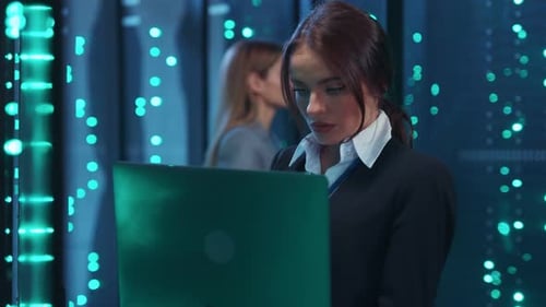A Professional Woman in a Suit Navigates a Data Center Using Devices