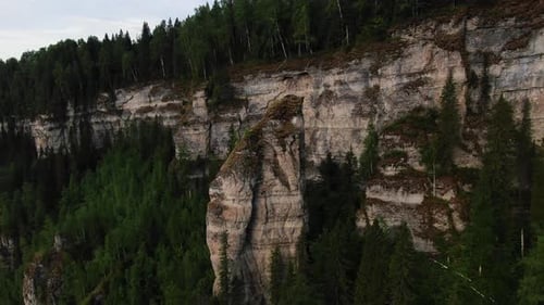 Aerial View of Majestic Forest Cliffs Along Serene River