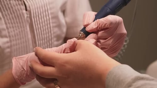 Close-up of Manicurist Filing Nails With Electric File