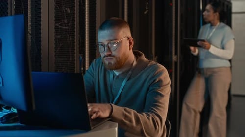 IT Engineer Works in Data Center on Laptop