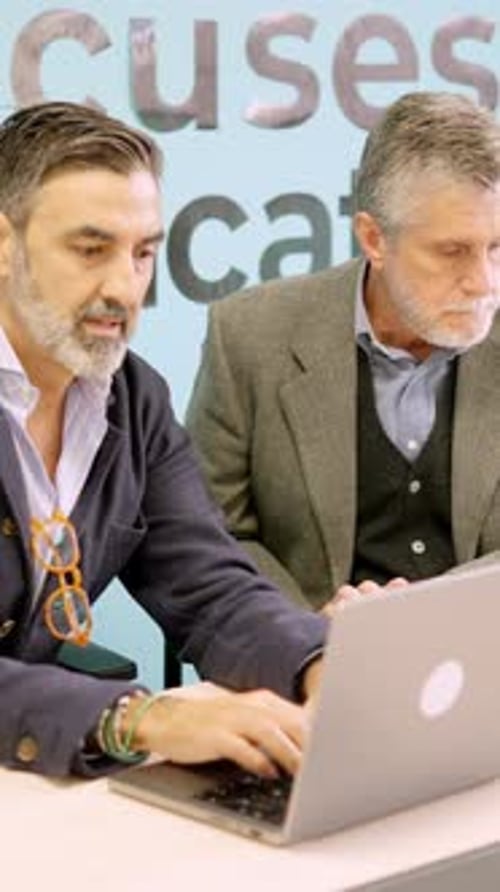 Professional Men Collaborating on Laptop in Modern Office