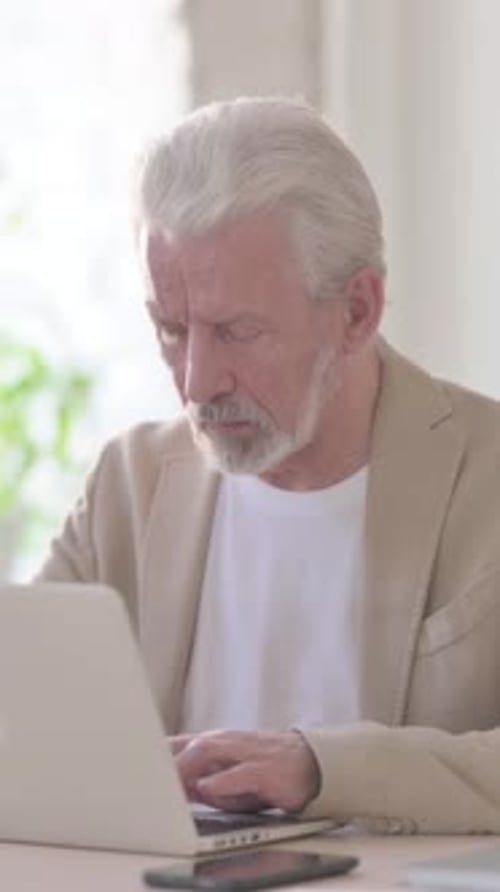Busy Old Man Using Laptop in Office, Vertical Video