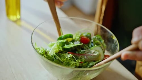Fresh Green Salad Preparation with Wooden Utensils