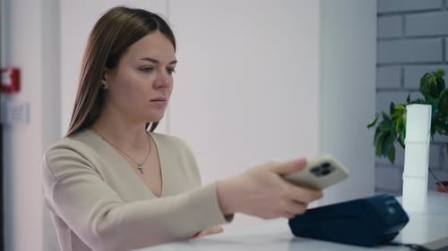 A Woman Makes Payments Using Shortrange Wireless Data Transmission Technologies Using a Mobile Phone
