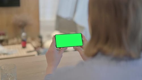 Young Woman Holding Phone with Chroma Key Screen