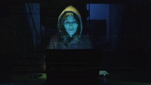 Female Hacker In Hoodie Coding On A Laptop With Overlapping Computer Code. medium shot