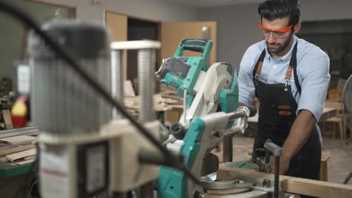 Carpenter is working together at workshop.