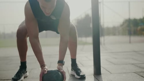 Fit Man Exercising with Medicine Ball Outdoors