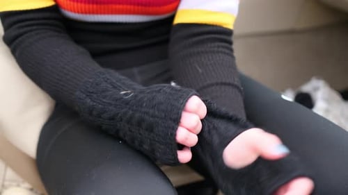 Close Up of Female Hands Fixing Gloves on Car Seat, Preparing For Roller Skating
