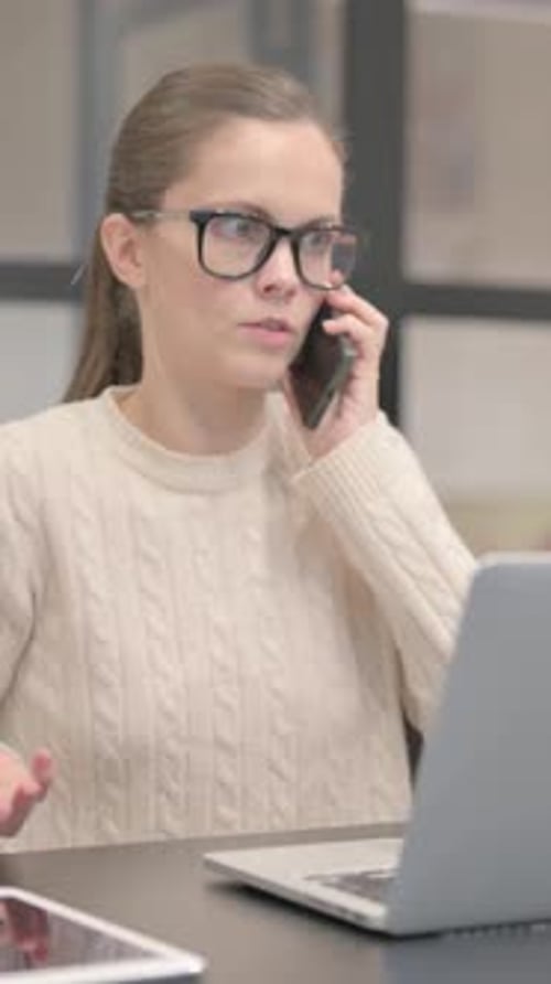 Young Woman Talking on Phone at Desk