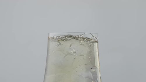 Ice cubes falling into drink with bubbles