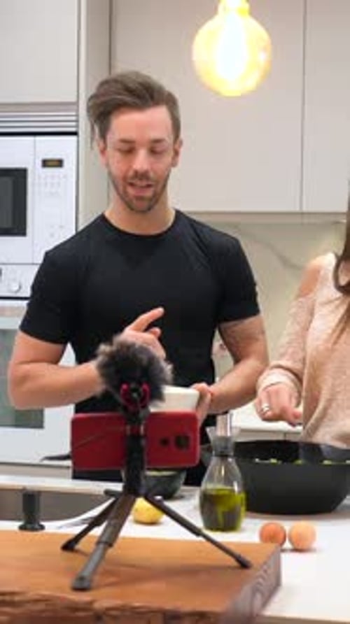 Equipo de vlogueros saludando a la cámara mientras graban un vídeo cocinando
