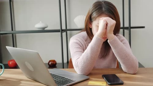 Woman Looks Frustrated with Computer and Phone