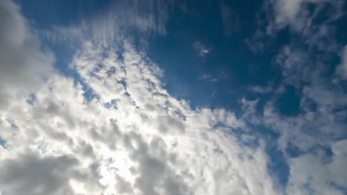 Weiße Baumwollwolken fliegen schnell am Himmel. Schwere Wolken vor dem Hintergrund des blauen und sonnigen Himmels
.