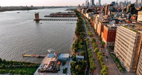 Flight above the waterfront of Hudson River. Beautiful green park and highway separating water