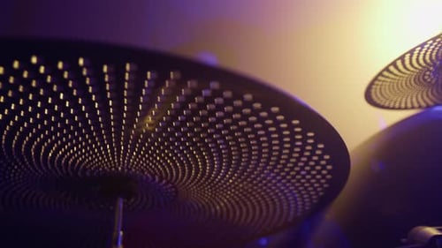 Tiefer Winkel einer Schlagzeugerin, die im Musikstudio Schlagzeug übt und sich auf das Becken konzentriert