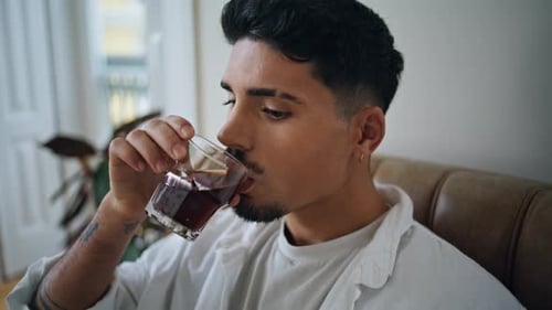 Man Enjoying a Drink Indoors Relaxing in Chair