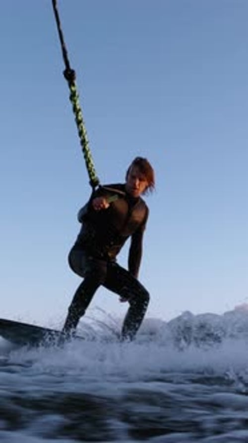 Man Wakeboarding on Choppy Ocean Waters, Blue Sky