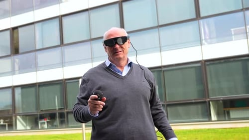 Aged Man Interacting with Augmented Vision Goggles Outside the Office