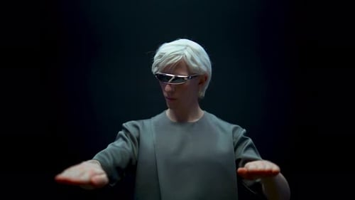 Man in Futuristic Glasses Gesturing on Black Background