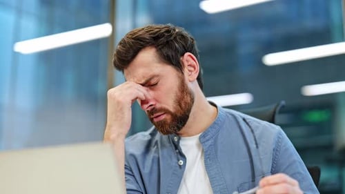 Tired Businessman in Office Suffering From Headache and Eye Strain
