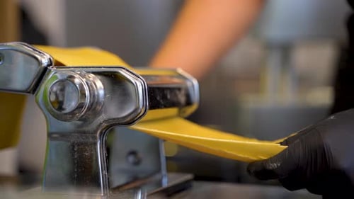 Making homemade pasta at kitchen with a machine 4K