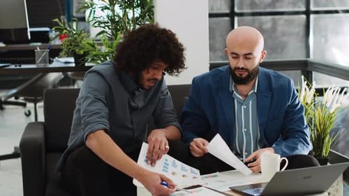 Men Collaborating on Data in Modern Office