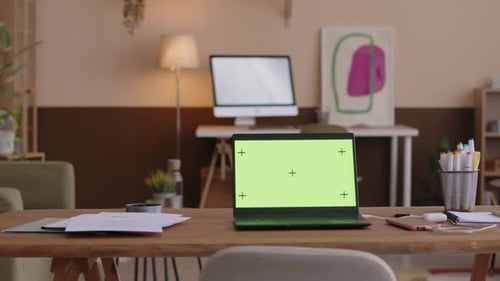 Laptop with Green Screen on Desk at Home Office