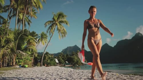 Young Woman Walking on the Beach Holding a Snorkel Mask in Slow Motion