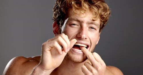 Studio, man and face with floss for teeth whitening, hygiene and grooming with check for dental