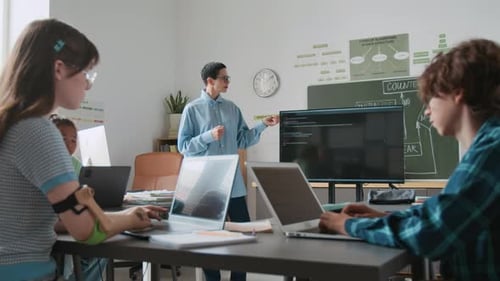 Teacher teaching coding to students in classroom