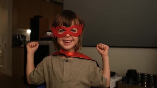 A Young Hero Wearing a Red Mask and a Flowing Cape Confidently Poses with Flair and Style