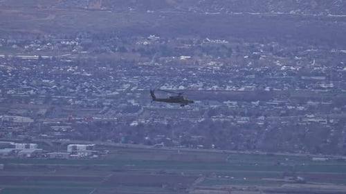 A Boeing AH-64 Apache Helicopter flying through Utah Valley.