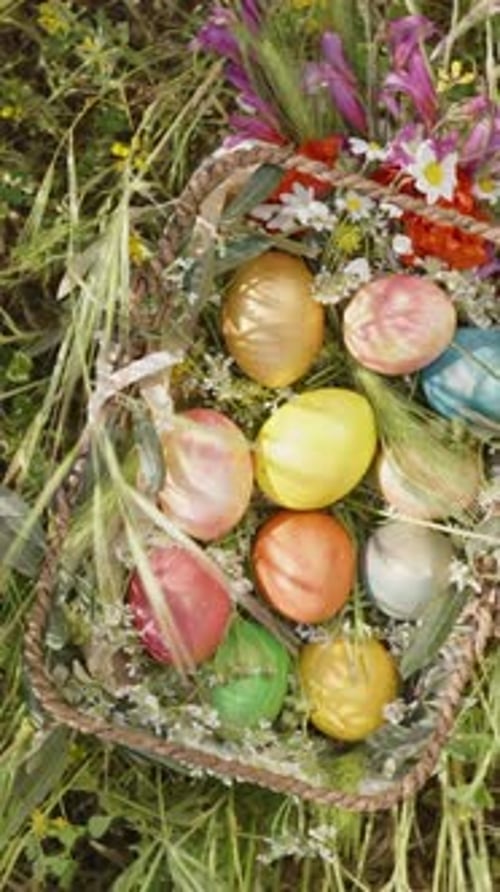 Vertical video. A Top-Down View of a Basket Brimming with Colorful Easter Eggs and Flowers, Resting