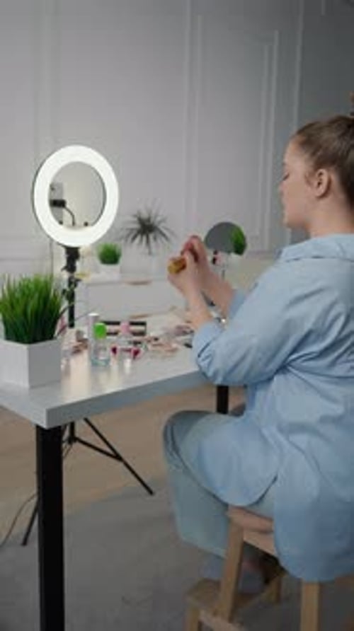 Alegre artista de maquillaje archivando un tutorial en vídeo para un blog en las redes sociales en Studio Influencer